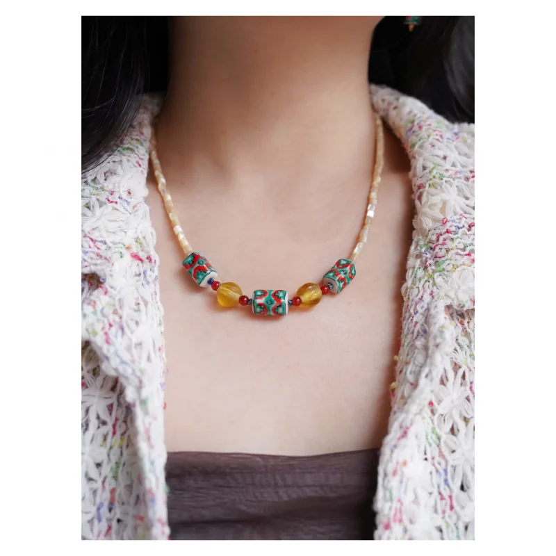 Model wears handmade beaded nautilus necklace, combining oceanic inspiration with a touch of vintage style.