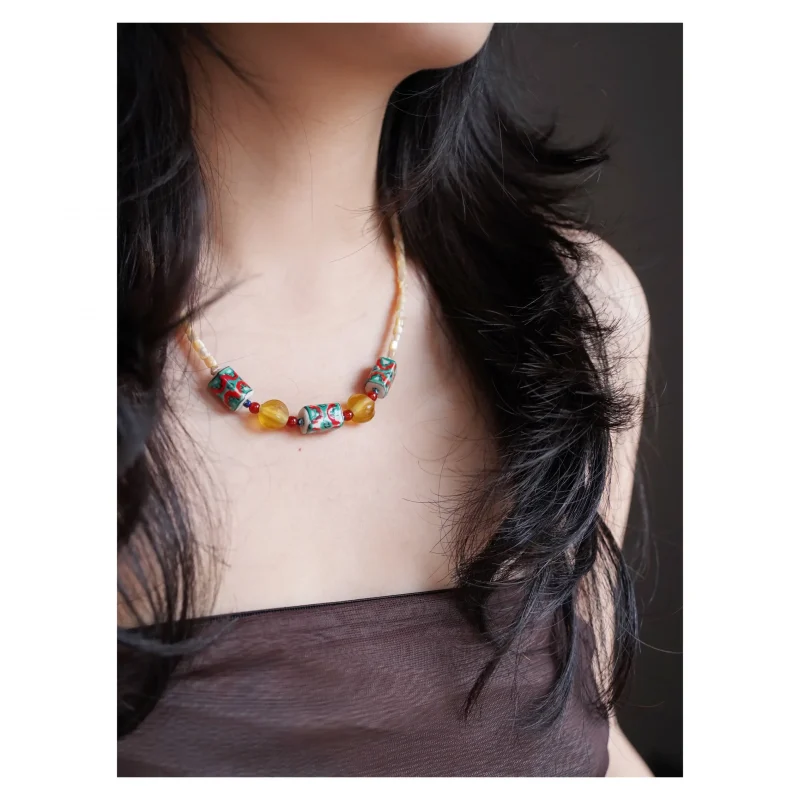 Model wears colorful nautilus shell necklace, showcasing handmade artistry and ocean-inspired elegance.