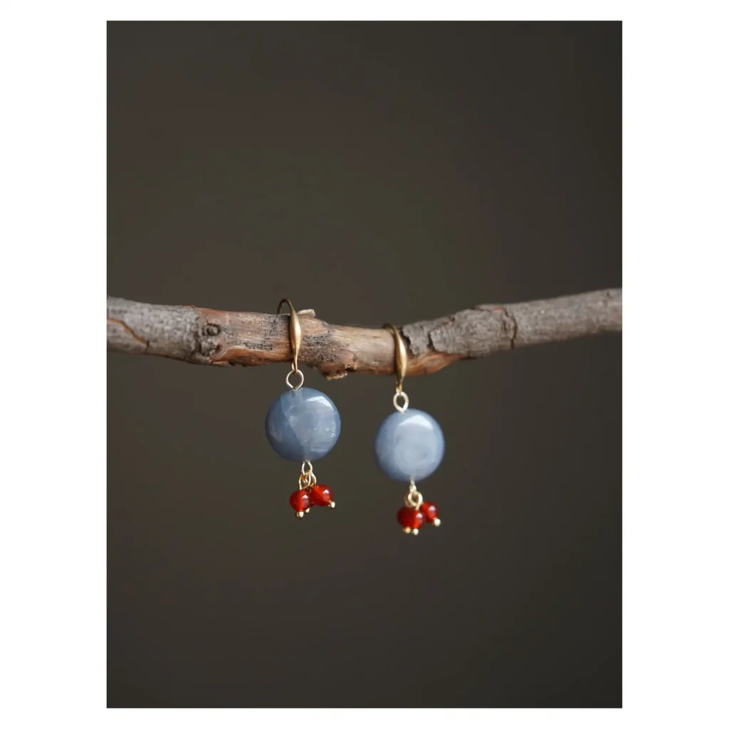 Natural gemstone earrings reflect Dunhuang-inspired elegance as artisans handcraft vintage charm with ancient textures.