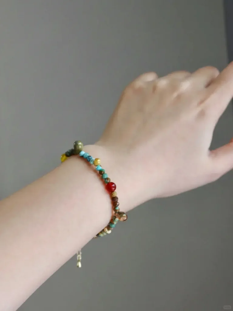 Model showcases vintage colorful beaded bracelet, adding cheerful energy and vibrant layering to the overall look.