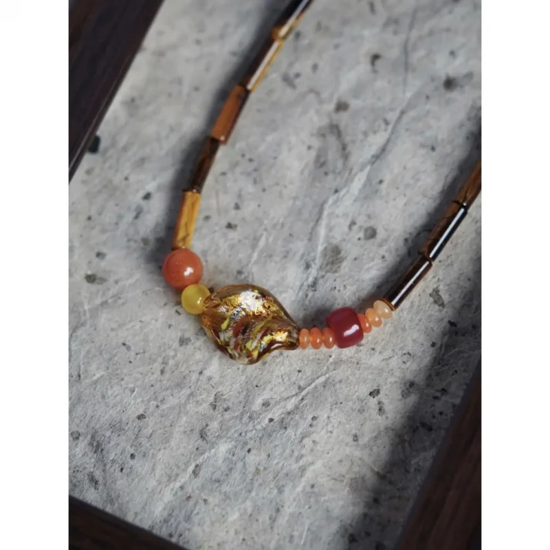 This vintage-style necklace pairs glass beads with tiger’s eye to create a timeless boho accessory.