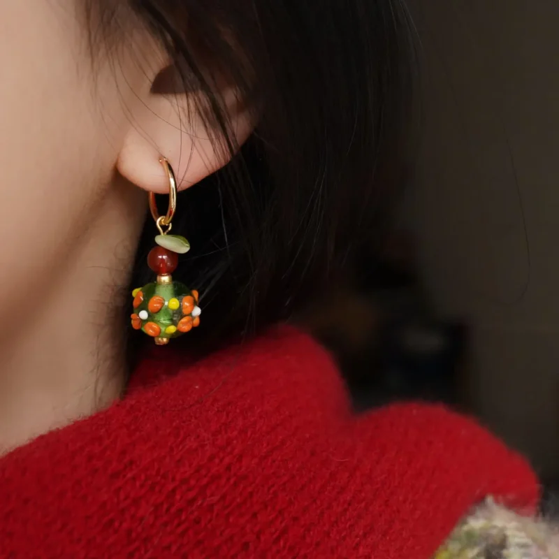 Model wearing colorful glass bead clip-on earrings, expressing vintage Bohemian flair