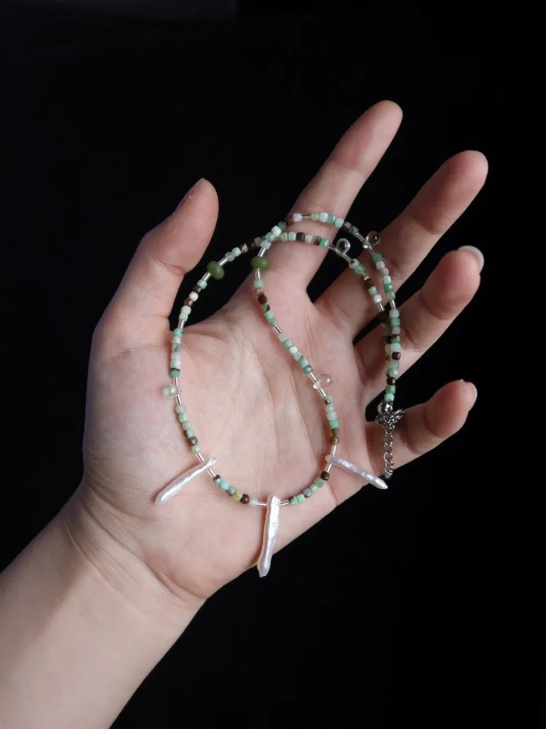 Delicate handmade necklace features natural jade accents to express timeless vintage charm