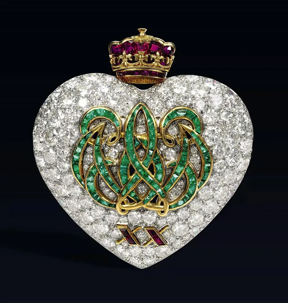 Illustration of the Duke of Windsor's heart-shaped anniversary brooch, featuring the initials "W" and "E" and Roman numerals XX set with rubies, symbolizing love and commitment.