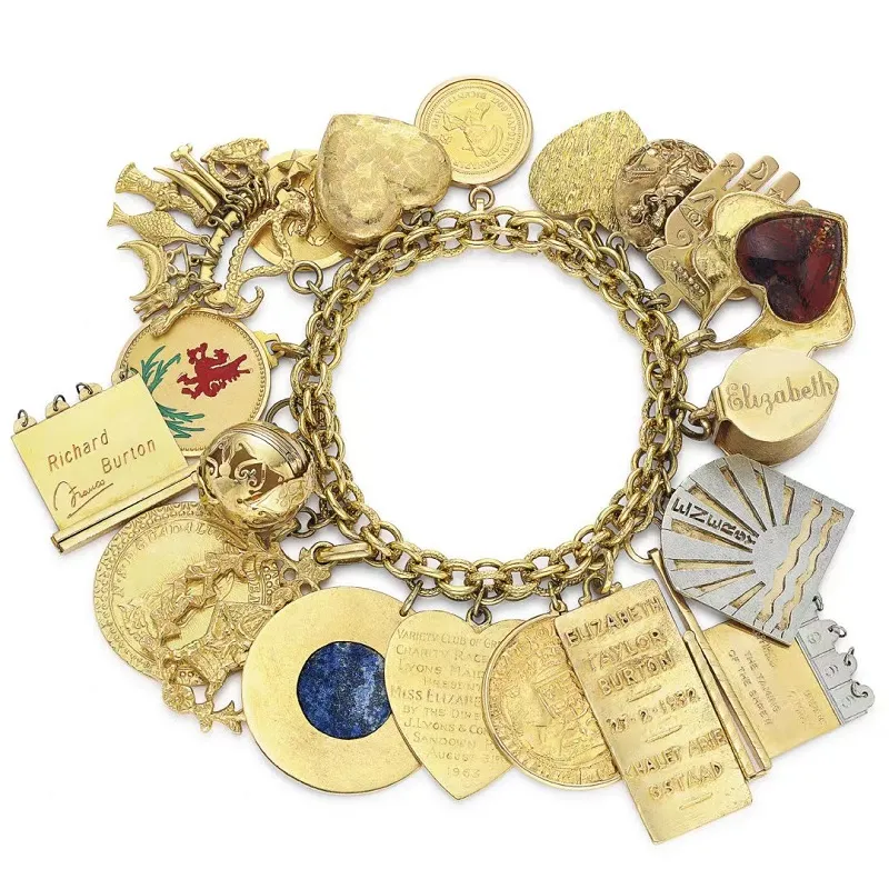 Illustration of Elizabeth Taylor's charm bracelet with ancient coins, a cross, Egyptian amulets, the Star of David, and turquoise talismans.