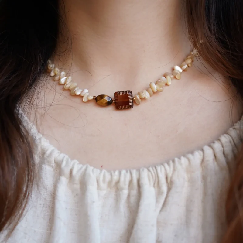 Model showcases a handmade natural stone necklace with vintage-inspired design and artisan charm.