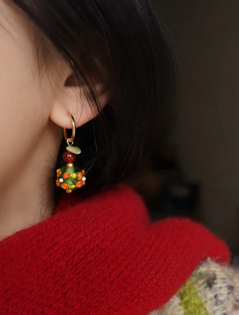 Model wearing Nepal glass bead earrings, showcasing hand-painted details and artistic Bohemian charm.