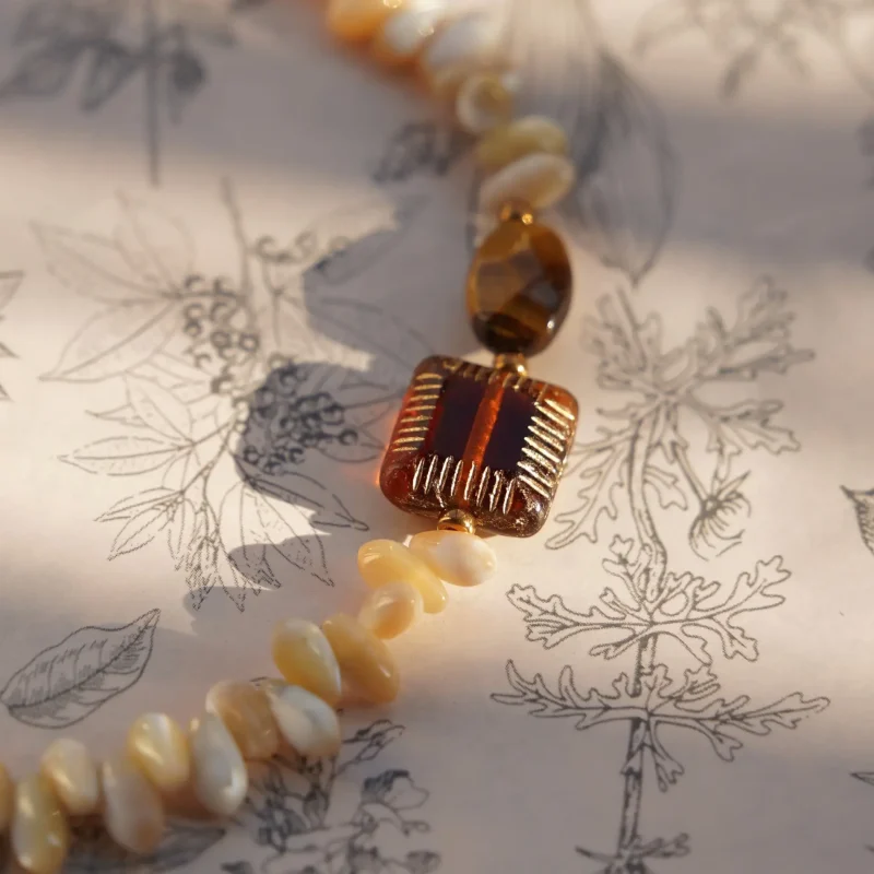 Bohemian-style necklace handcrafted with Tonna shell beads and tiger's eye for everyday vintage charm.