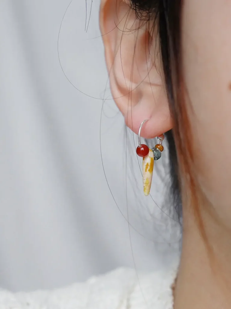 Model wearing handmade silver hoop earrings with a unique design, showcasing exquisite charm.