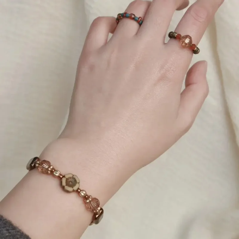 The model wears handcrafted beaded jewelry that highlights vintage elegance and artisanal detail.