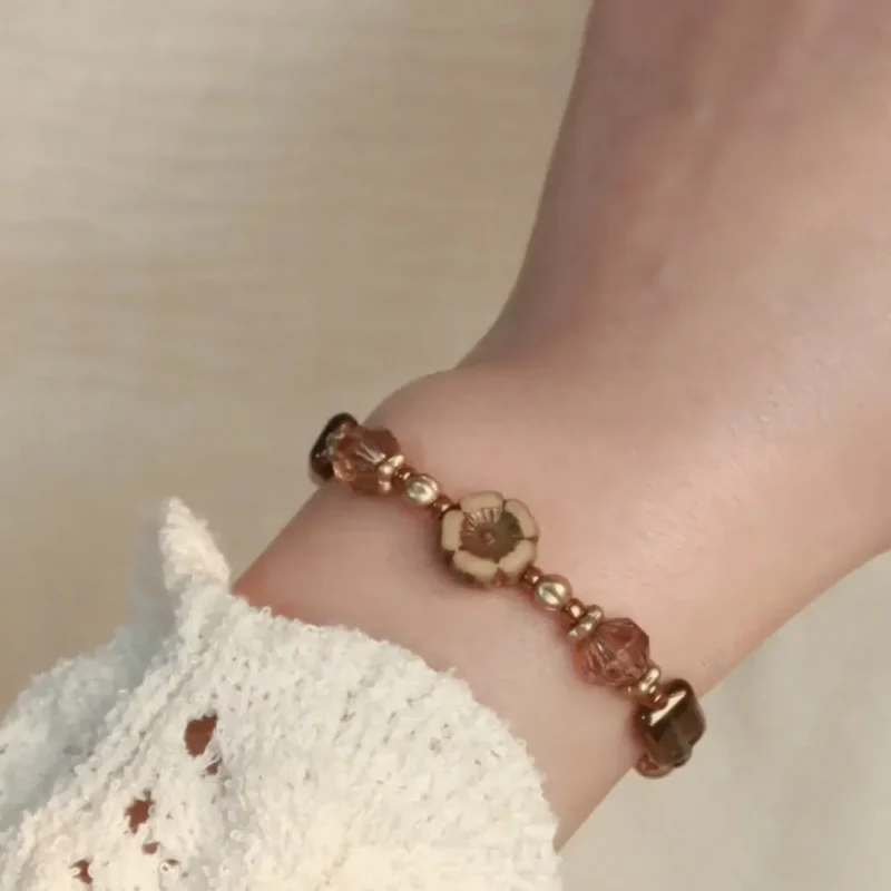 The model wears a handmade brown glass bead blacelet that highlights vintage tones and natural elegance.
