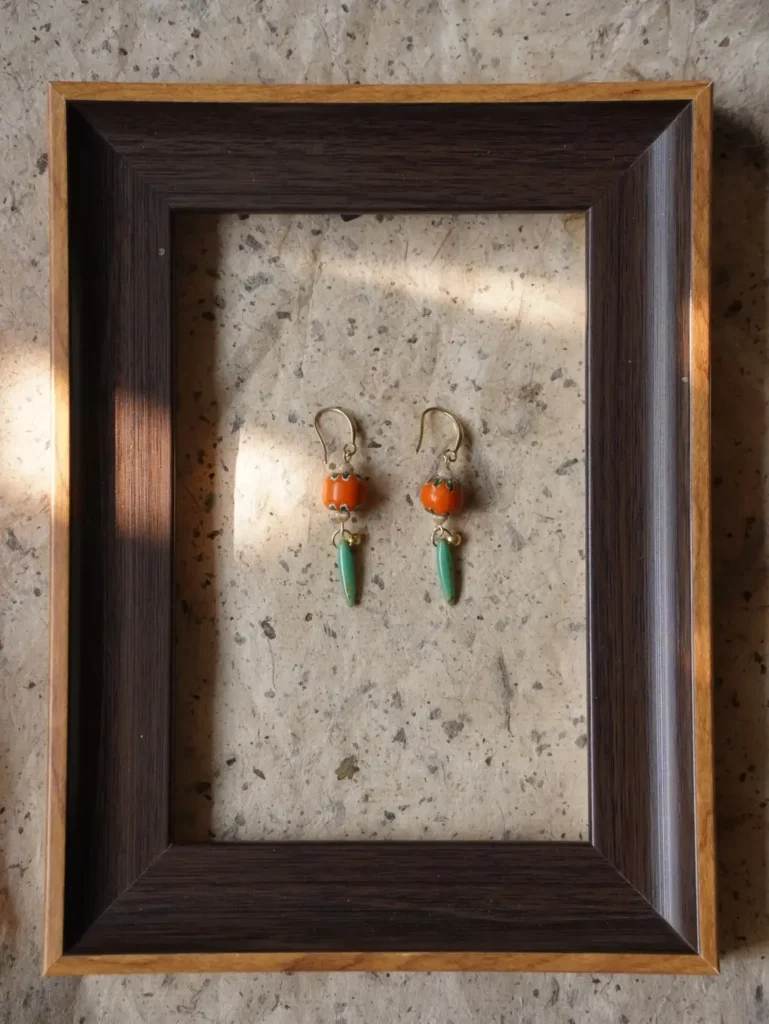 Handmade orange persimmon earrings featuring delicately hand-painted Nepalese glass beads in a vintage-inspired design.