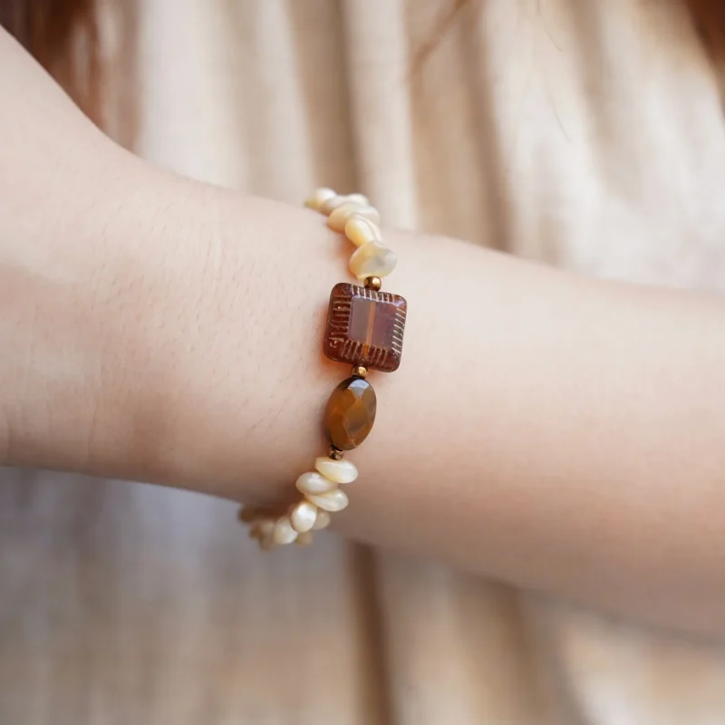Model showcases a handmade vintage beaded bracelet with unique artisan design and character.