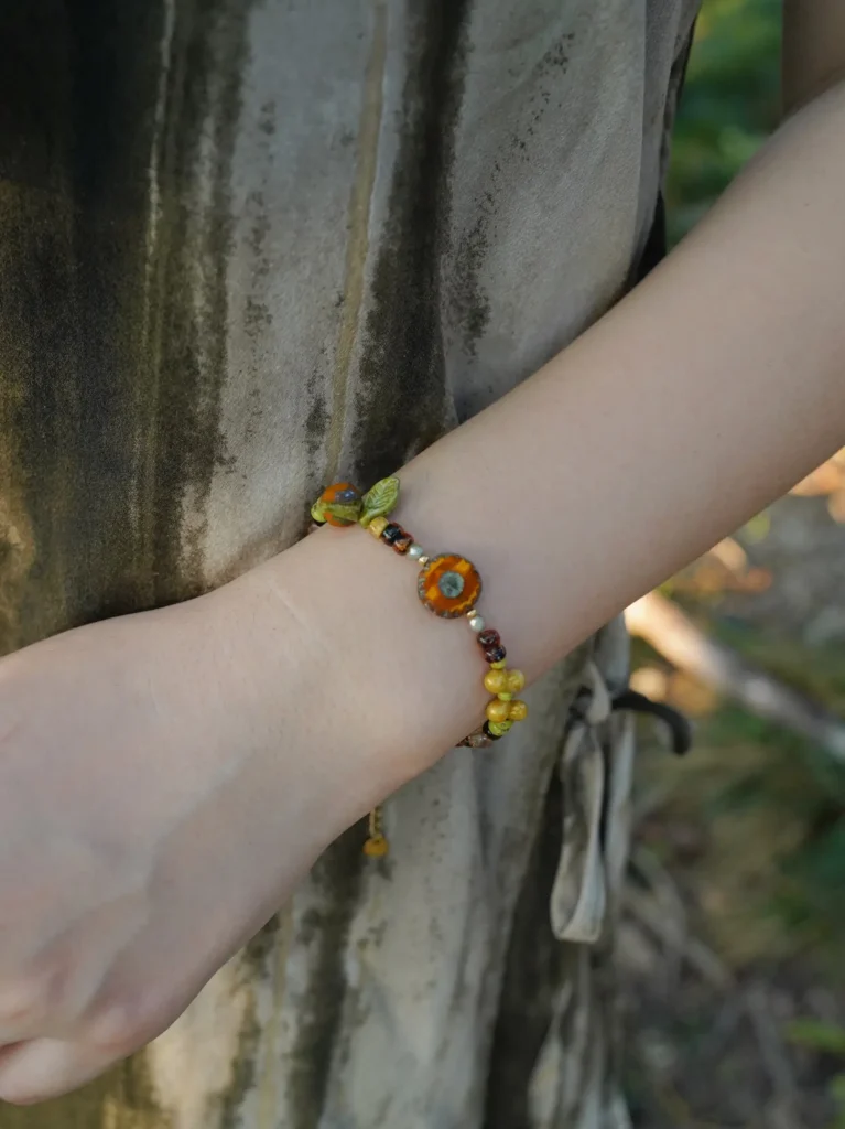 Model wears floral bead bracelet that blends seamlessly with nature-inspired styling