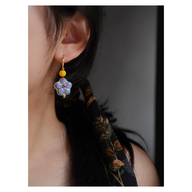 Model wears hand-painted ceramic bead earrings that highlight a fresh, graceful elegance