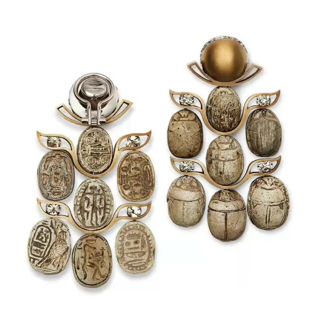 Illustration of a sacred scarab-themed jewelry piece by Hemmerle, featuring an ancient Egyptian scarab seal as the centerpiece in an archaeological revival style.