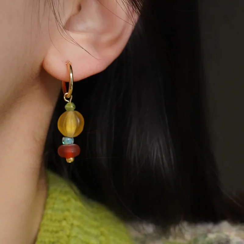 Model wearing colorful glass bead hoop earrings, highlighting handcrafted vintage elegance