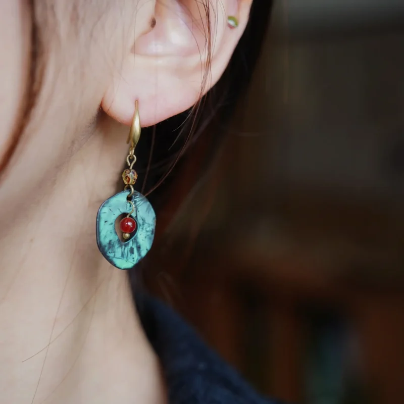 A woman gracefully wears handmade round earrings, showcasing timeless elegance and craftsmanship.