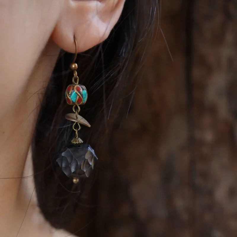 Model wearing handcrafted vintage earrings highlights their elegant Tibetan-inspired style and artistic charm.