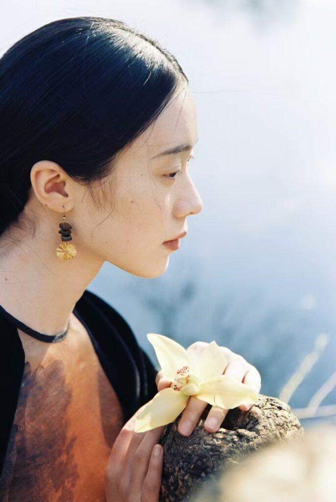 Model wearing PeonyJewels handmade vintage earrings in a natural outdoor setting