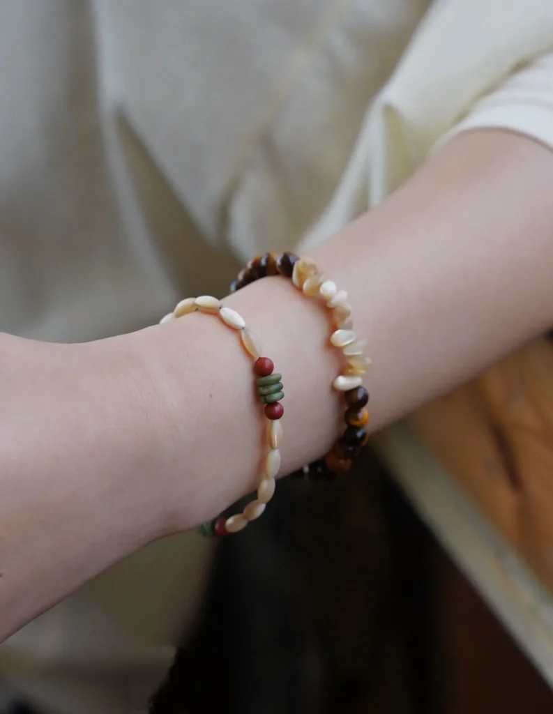 Layered handmade bracelets displayed indoors, highlighting their intricate details, natural textures, and artisanal charm.
