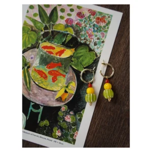 Handmade earrings feature colorful glass beads on 14K gold-plated copper hoops, perfect for craft and art lovers.
