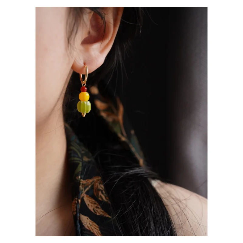 A model wears 14K gold-plated copper earrings, showcasing the handcrafted color combination and elegant design.