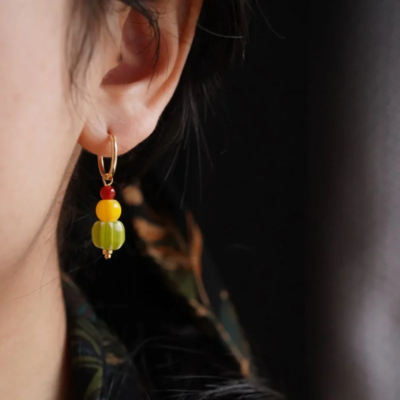 A model wears 14K gold-plated copper earrings, showcasing the handcrafted color combination and elegant design.