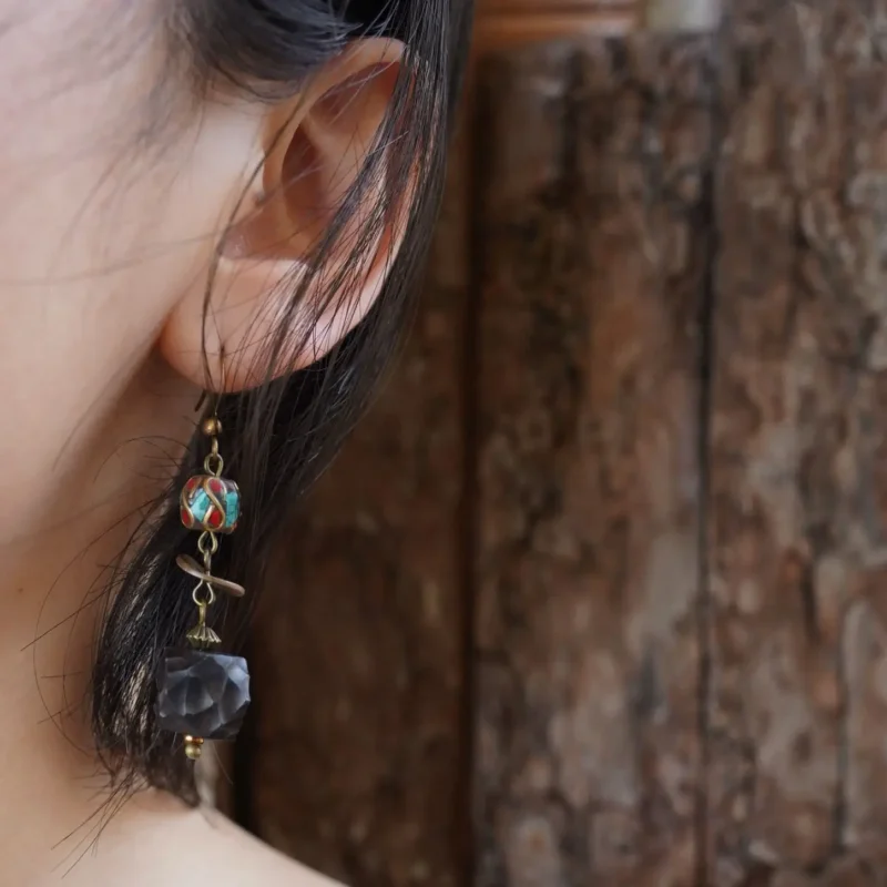 Model wearing Tibetan earrings, showing their artistic Tibetan-inspired style.