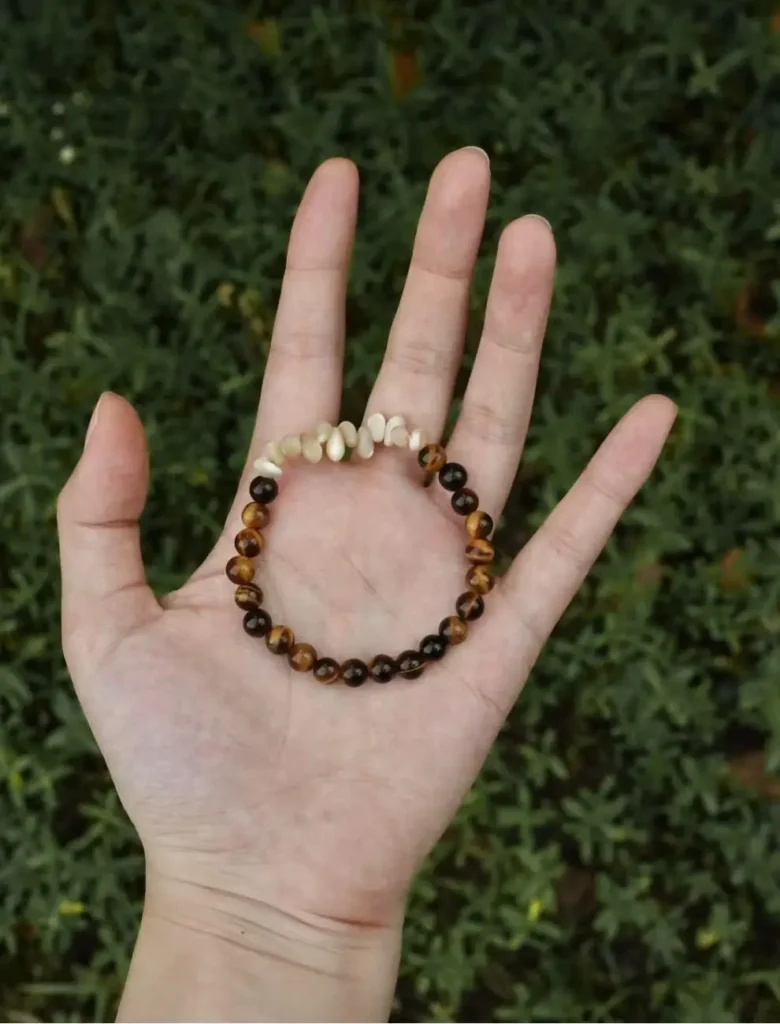 Natural Tiger’s Eye beaded bracelet shown in sunlight, highlighting its rich textures and polished surface.