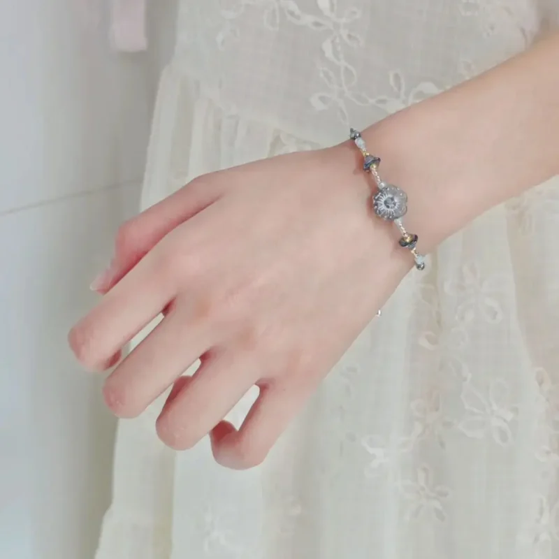 A woman wearing a handmade beaded bracelet, showcasing its elegant fit and natural layering style.