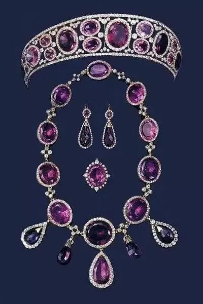 A detailed close-up shot of a purple amethyst crown and matching earrings