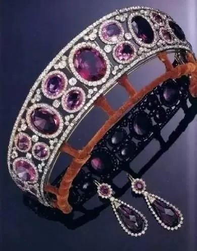 A very close-up detail shot of an amethyst crown and matching earrings, highlighting the intricate craftsmanship and gemstones.