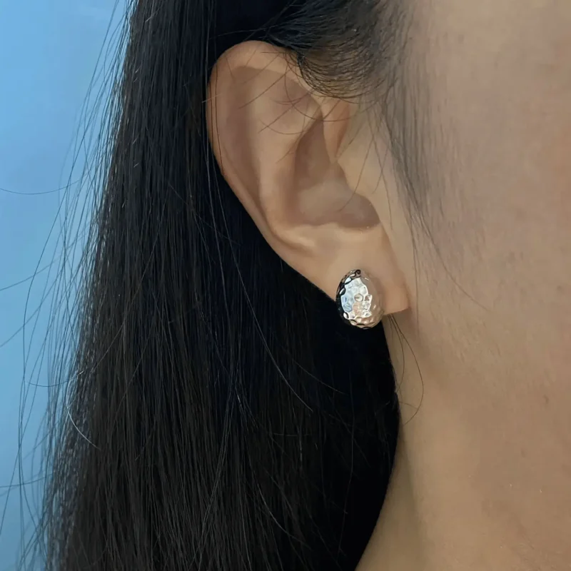 Model wearing handcrafted sterling silver stud earrings, highlighting minimalist design and everyday elegance.
