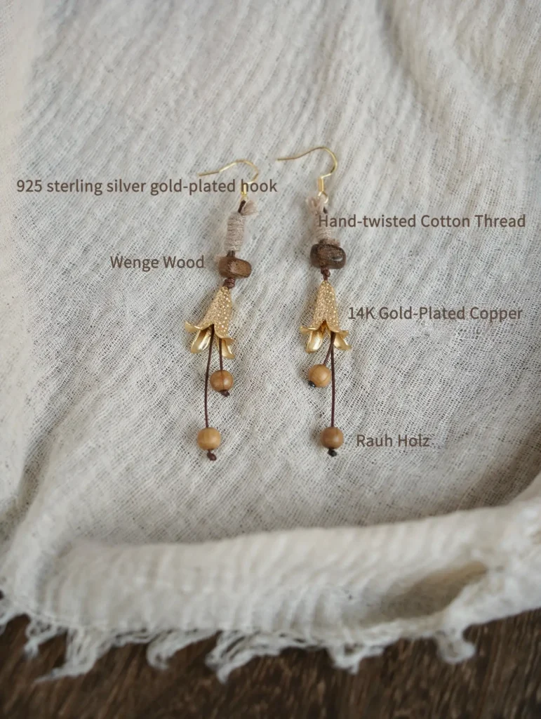 Detailed view of handmade Wabi-Sabi earrings showing natural wood, cotton thread, and gold-plated hook components.
