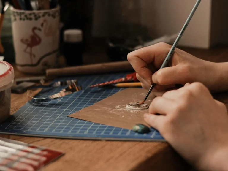 Close-up of jewelry making with precision tools and clay for gemstone setting indoors