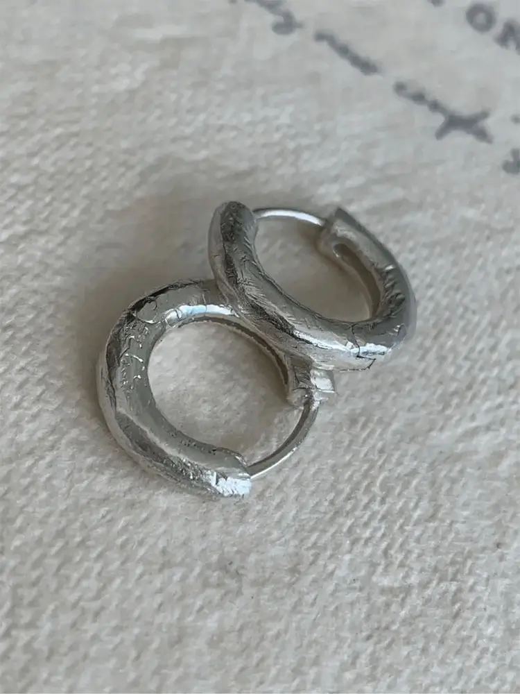 Large silver hoops displayed to highlight minimalist design, lightweight feel, and artisanal finishing.
