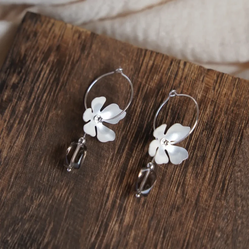 Minimalist silver ear hoop featuring a matte flower, perfect for elegant vintage style.