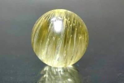 Close-up of fake rutilated quartz made with fine glass tube fibers mimicking rutile needles.