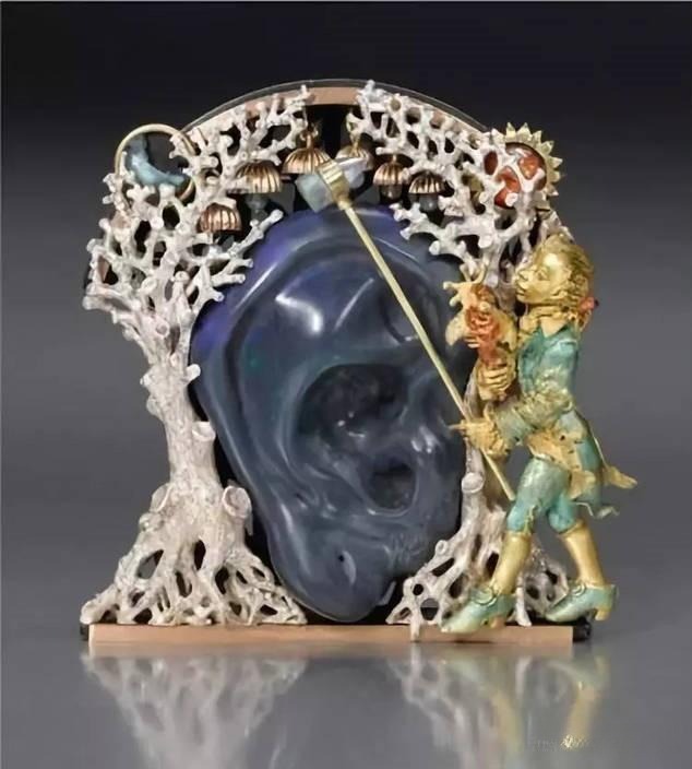 Jewelry artwork featuring a young boy and an ear motif, exploring surreal themes and emotional symbolism