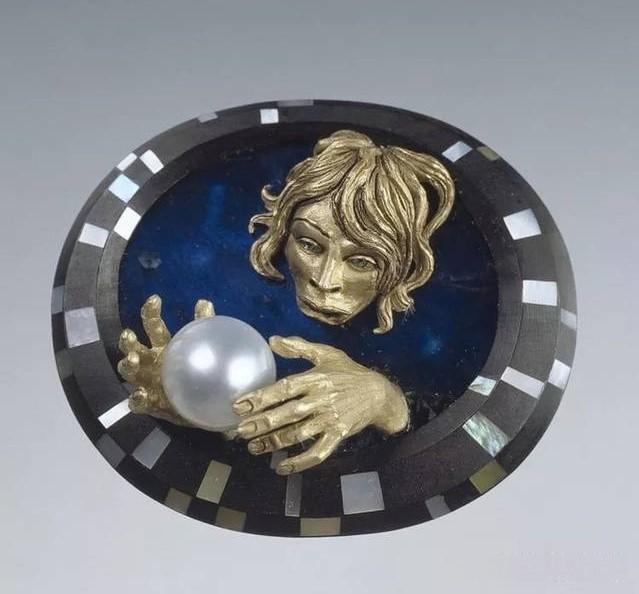 Jewelry piece depicting a young boy playing with pearls, blending innocence with surreal artistic imagination