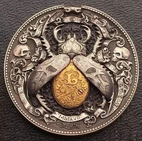 Mechanical coin engraved with a beetle design; pressing the tiny edge button opens the wings to reveal a 22K gold body inside.