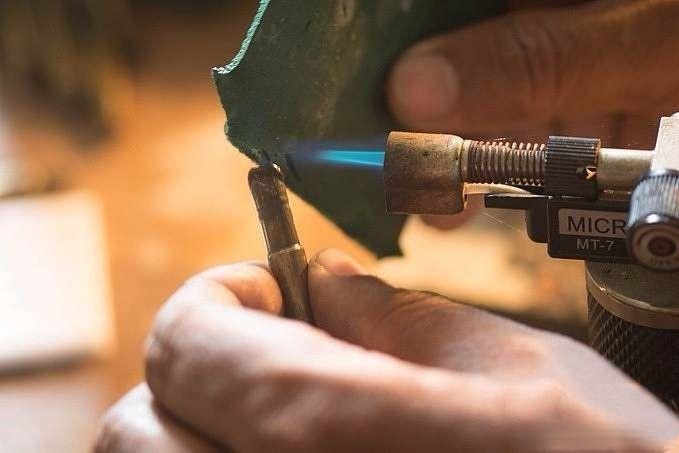 Melting adhesive on the copper dop stick to secure the stone in place.