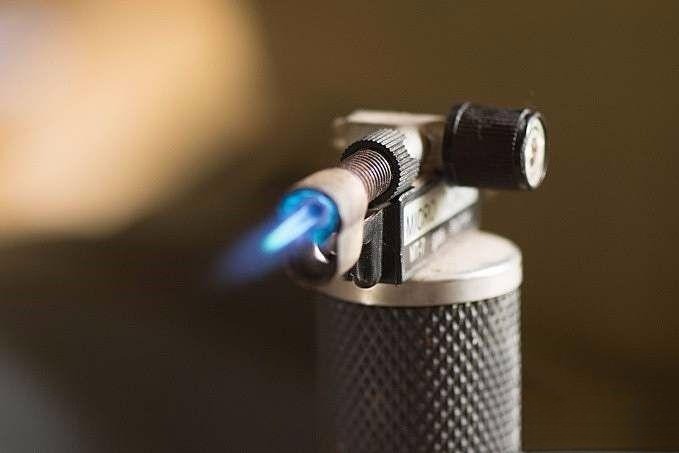 Reheating shaping wax to attach the gemstone securely to the dop stick during the cutting process