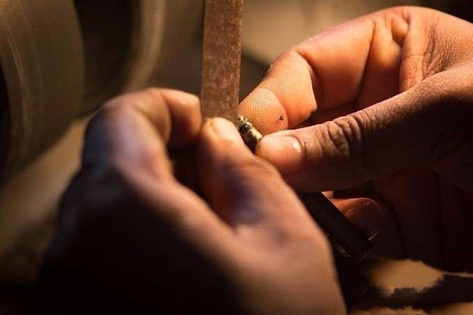 Removing excess wax from the dop stick to securely hold the stone for precise shaping