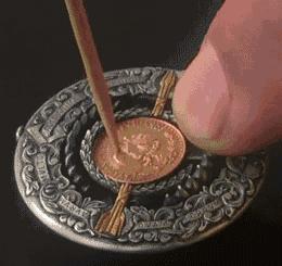 Collection of Roman Booteen’s mechanical coins featuring intricate engravings, hidden gears, and creative moving designs.