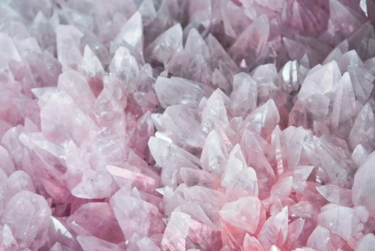 Close-up of rose quartz crystals highlighting their pink color and translucency, illustrating gemstone windowing issues.