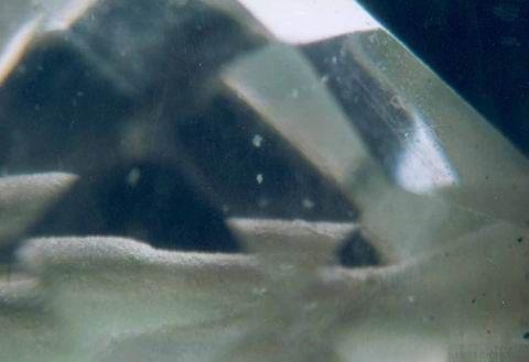 Synthetic quartz crystal displaying breadcrumb-like inclusions inside.
