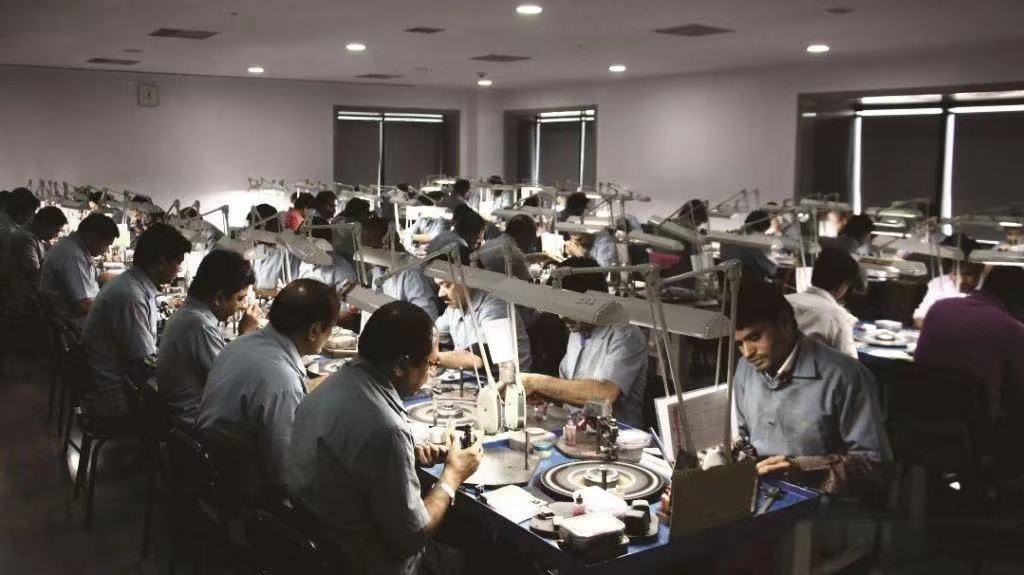 Indian workers meticulously processing rough diamonds and gemstones in a factory, highlighting the country's central role in the global diamond industry.