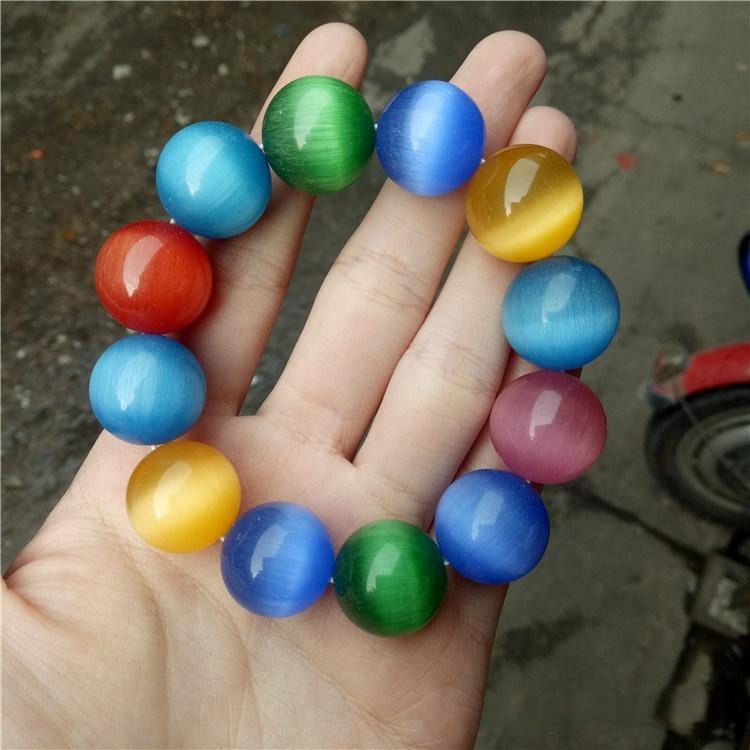 A bracelet with multi-colored glass imitation gemstones, known as Cathaystone, displaying the cat's eye chatoyancy effect.